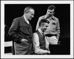 Hoagy and Hoagy Bix Carmichael standing behind Fred Rogers, who is playing the piano.