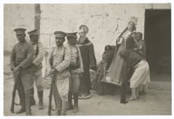 Item 0277a.  Series of photos with a group of four soldiers in the left foreground, and various religious statues behind them to the right. Three women are setting down a statue of the Virgin Mary to the left of the first statue. Door behind them at far right.