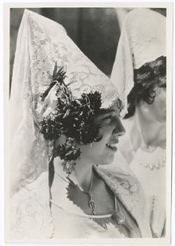 Item 0060. Close-up profile of young woman in mantilla. A second woman partially visible in background.