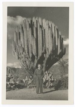Item 0453. Alexandrov standing in front of cactus.