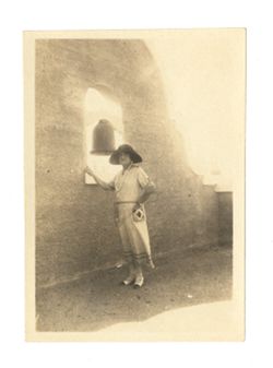 Margaret Howard standing beside a bell