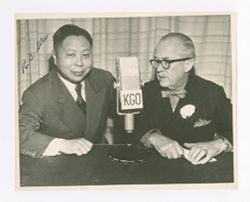 Roy Howard and another man in front of a microphone