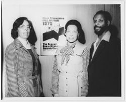 Mary Perry Smith, Margot Hicks and unidentified man in front of BFHFI poster