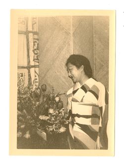 Woman wearing kimono posing next to flowers