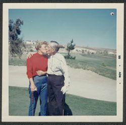 Hoagy Carmichael and an unidentified woman kissing on the golf course.