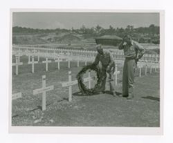 Roy Howard sets a wreath on a grave