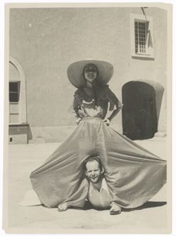 Item 0394. Various shots of Eisenstein and a young woman wearing a checked culotte with wide leg in the courtyard of the Hacienda. Eisenstein is lying on the ground, looking out from between the spread legs of the girl's culotte.
