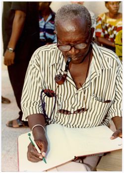 Ousmane Sembène writing in book