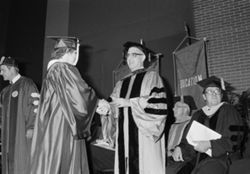 Chancellor Lester Wolfson shakes hands with IU South Bend graduate, 1980