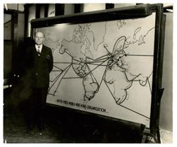 Karl A. Bickel stands in front of a map