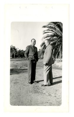 Roy Howard and man smoke by palm trees