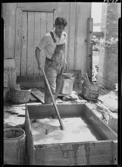 Dick Griffith stirring clay for potter