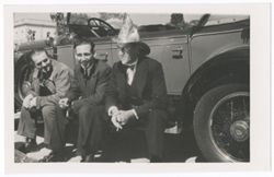 Item 52. Julio Saldivar, far right, and two unidentified men seated on running board of car. Saldivar wearing a helmet like that of the soldiers seen in Postcards 42-49 above.