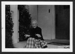 Lida Carmichael, sitting on a porch.