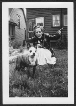 Georgia Carmichael kneeling in yard with dog.