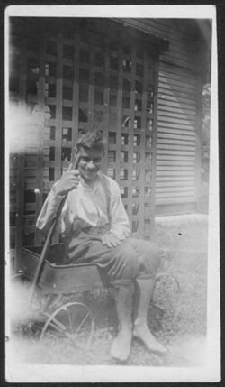 Noel Hall, sitting in a wagon, 14 years old.