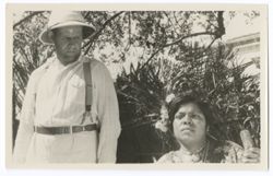 Item 0319. Standing left, Eisenstein. Seated, right, young Indigenous woman, head and shoulders only visible. Trees and building in background.