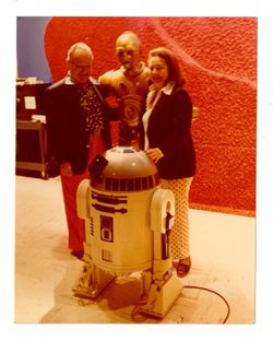 Jack Howard and Eleanor Harris-Howard posing with C-3PO and R2-D2 of Star Wars
