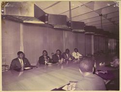 President Tubman seated with men in business attire at conference table