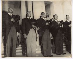 President Tubman and other digntaries stand with their hats over their hearts
