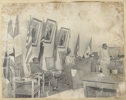 President William V. S. Tubman stands at podium in room with flags in background