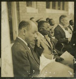 President Tubman and other dignitaries seated outside, examining documents
