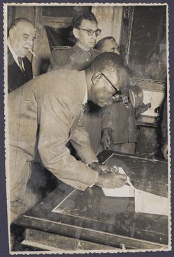 President Tubman signs a book in or near Toledo, Spain