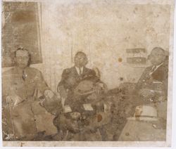 President Tubman, hat in lap, seated with companions