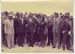 President Tubman enjoying a cigar while waiting with crowd