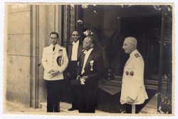 Four men in decorated dress stand together in door way