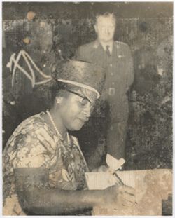 Mrs. Antoinette Tubman sits and writes in book