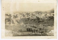 Scenic view of people on the streets and a town in the distance
