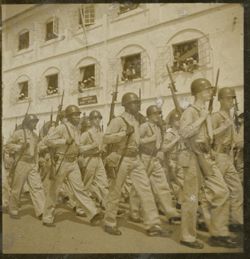 Military men march in parade past Monrovia Post Office