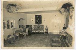 Interior room with table, chairs, large fireplace and painting on wall
