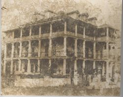 Three story building with pillars lining the outer rim of the porches on each level