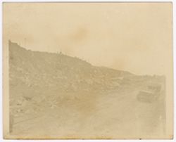 Machinery on top of rocks, a car on the road on the foreground
