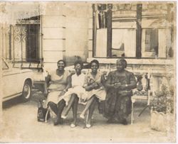 Four women preparing for an outing smile for the camera