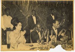 President William V. S. Tubman and others at dinner table clap together