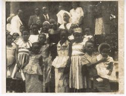 Portrait of adults and children gathered outside building