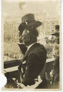 President William V. S. Tubman stands on balcony and lifts his top hat to the crowd