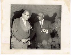 President William V. S. Tubman shakes hand with man in busines suit