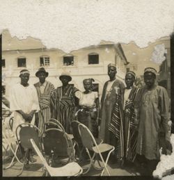 Group of men and women in formal and traditional dress pose for a portrait during military parade