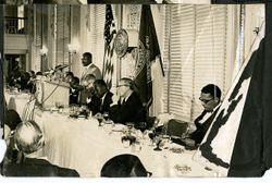 Man speaks to panel and guests at Press Club