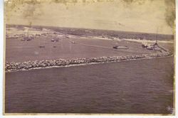 Aerial view of rock retaining wall and boats in harbor