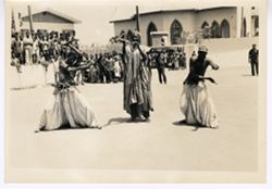 Group of men in traditional dress dancing and holding snake