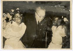 Postcard of Swiss hotel owner Herr Heits with two young girls at a reception