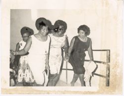 Four women walk up stairs together