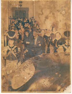 Guests walking down hallway with men in historical armour stand against wall