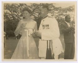 Couple in formal dress pose together at outdoor reception