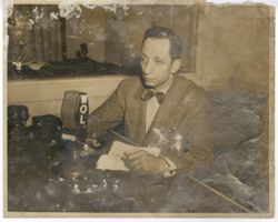 Radio host for WOL (MBS) sits in studio with his script